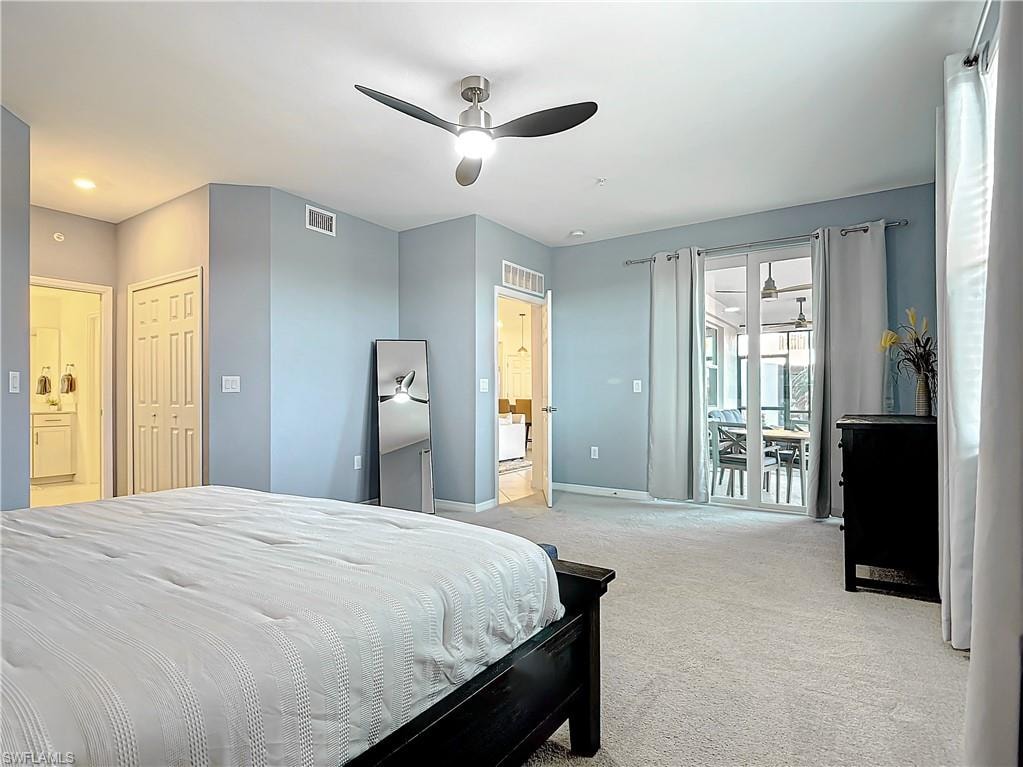Carpeted bedroom featuring access to exterior, a closet, ensuite bathroom, and ceiling fan