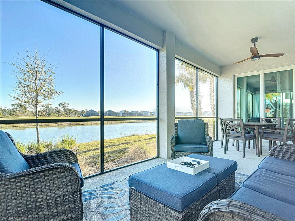 Sunroom / solarium featuring ceiling fan and a water view