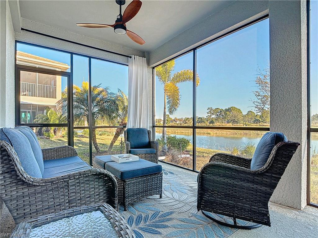 Sunroom with ceiling fan and a water view