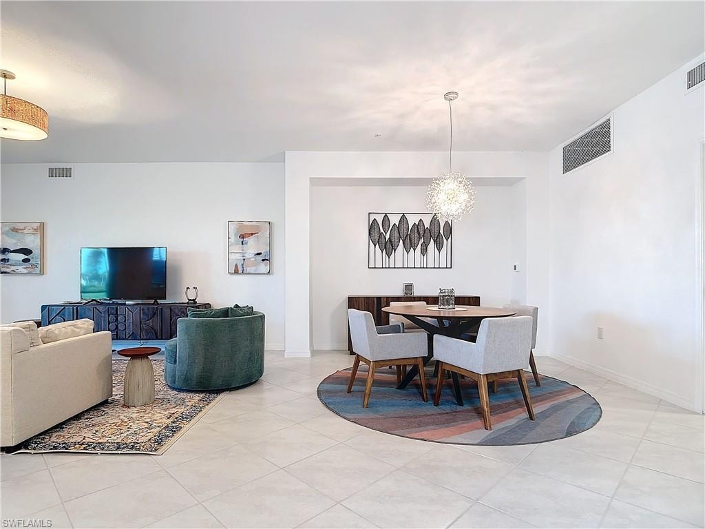 Dining area featuring light tile patterned flooring and a chandelier