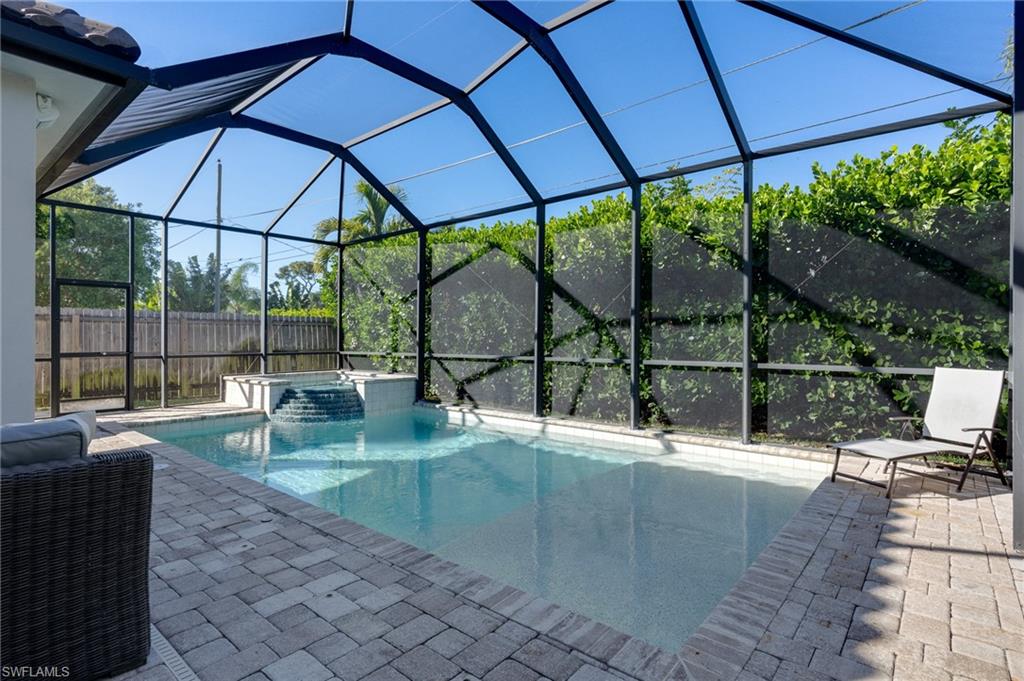 Combined pool / hot tub with a lanai, a sunroom, and a patio