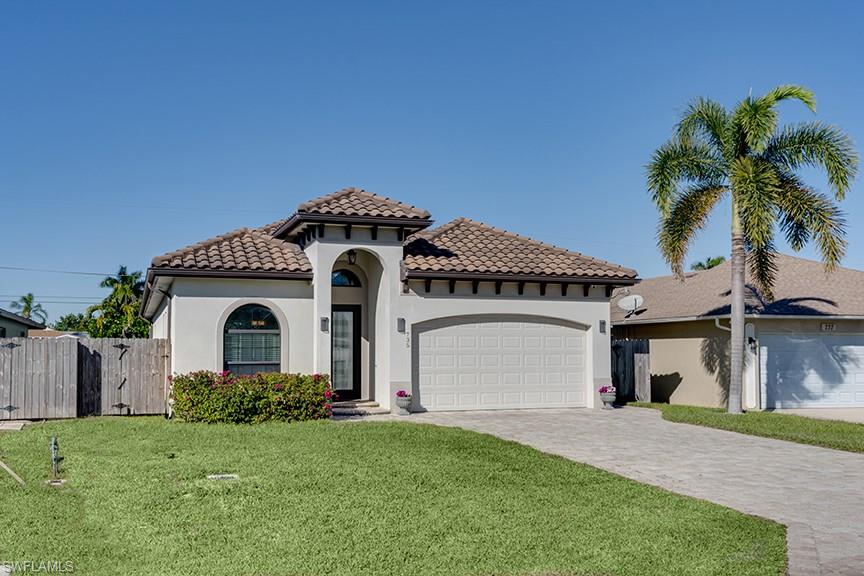 Mediterranean / spanish-style house featuring decorative driveway, stucco siding, a garage, and a gate
