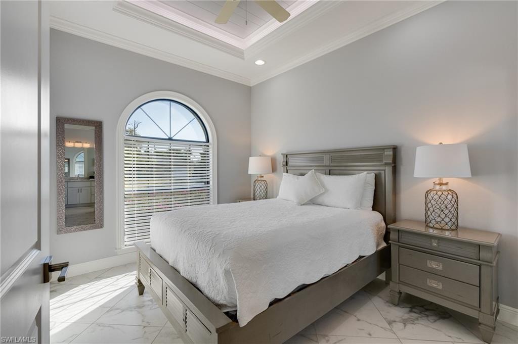 Bedroom with ornamental molding, a tray ceiling, ceiling fan, light marble finish floors, and recessed lighting