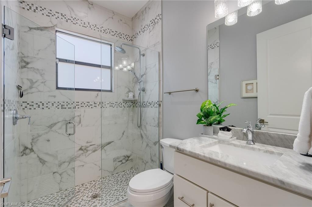 Bathroom with vanity and a marble finish shower