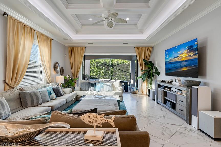 Living room with crown molding, light marble finish flooring, a ceiling fan, coffered ceiling, and recessed lighting
