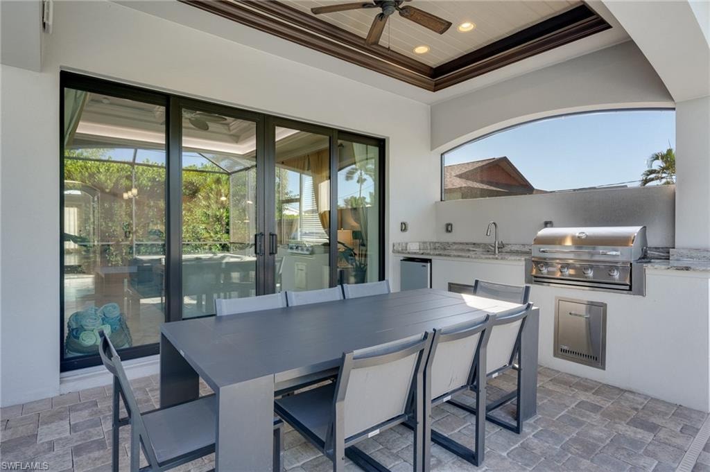 View of patio with an outdoor kitchen / dining area and a ceiling fan
