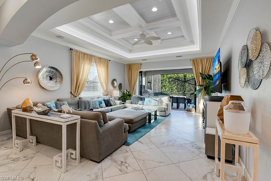 Living room featuring coffered ceiling, light marble finish floors, crown molding, plenty of natural light, and recessed lighting