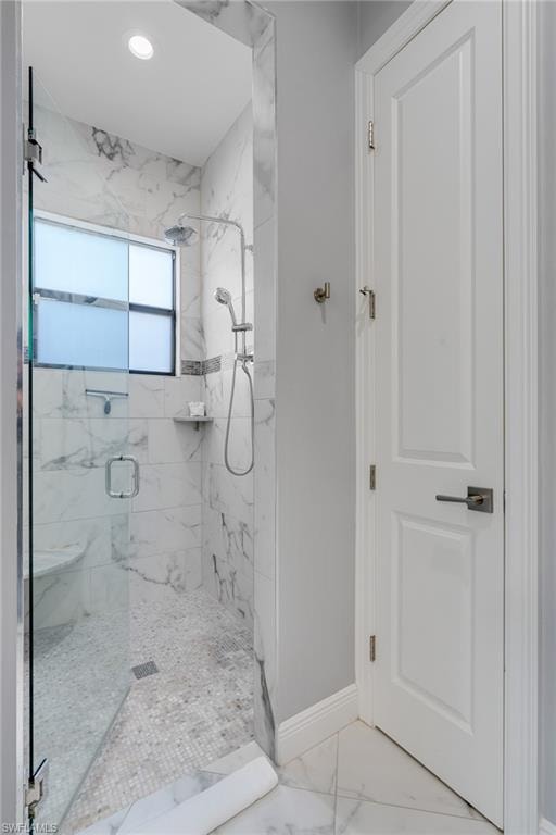 Bathroom featuring a marble finish shower, marble look tiles, and recessed lighting