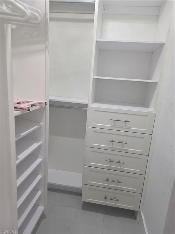 Walk in closet with light tile patterned flooring