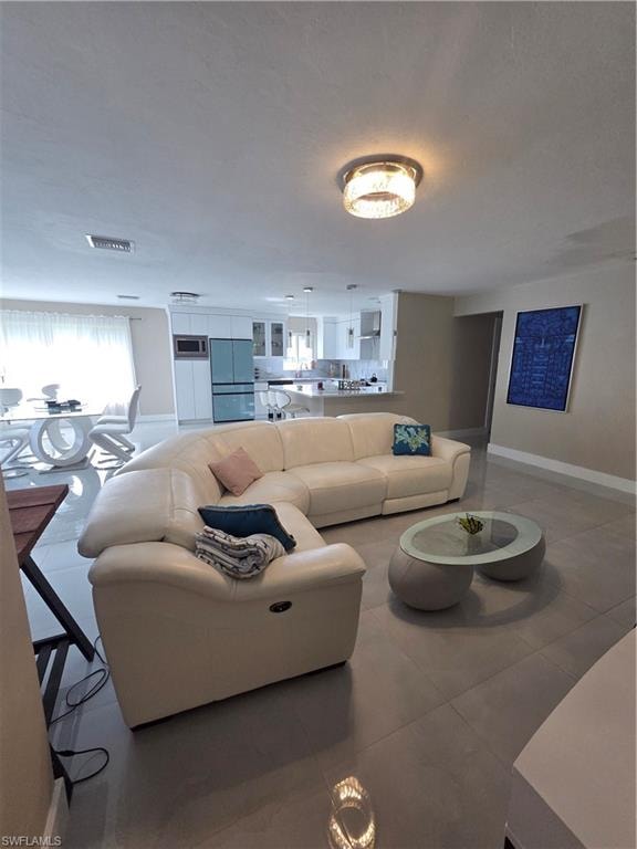 Tiled living area featuring baseboards