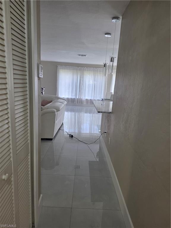 Hall featuring baseboards and a textured wall