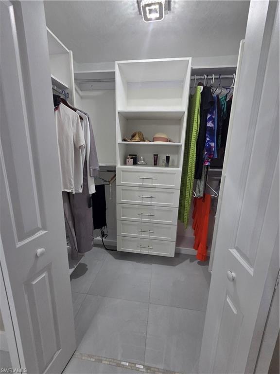 Spacious closet featuring light tile patterned flooring