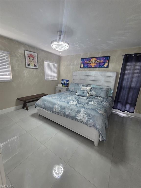 Bedroom with baseboards and tile patterned floors