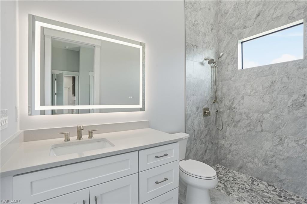 Full bath with a tile shower and vanity