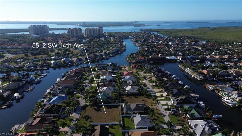 Aerial view of property and surrounding area featuring a large body of water and nearby suburban area