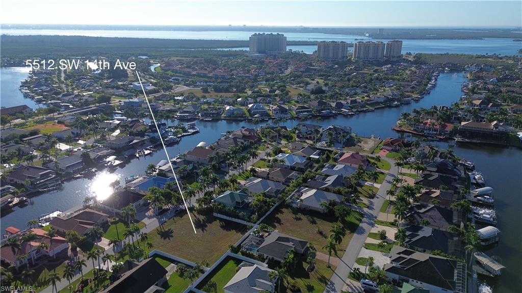 Aerial view of property and surrounding area featuring a large body of water and nearby suburban area