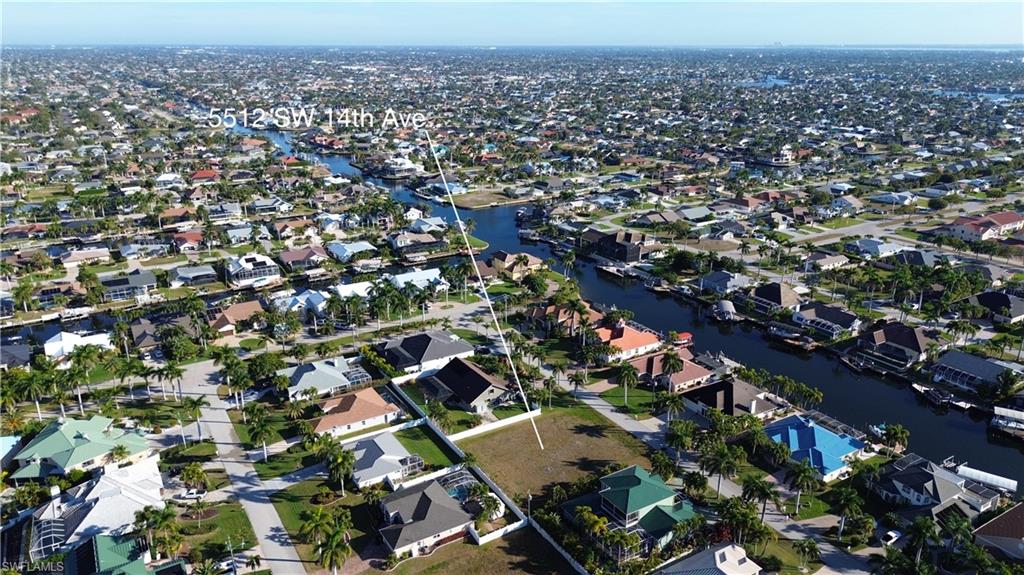 Aerial view of property and surrounding area featuring nearby suburban area and a nearby body of water