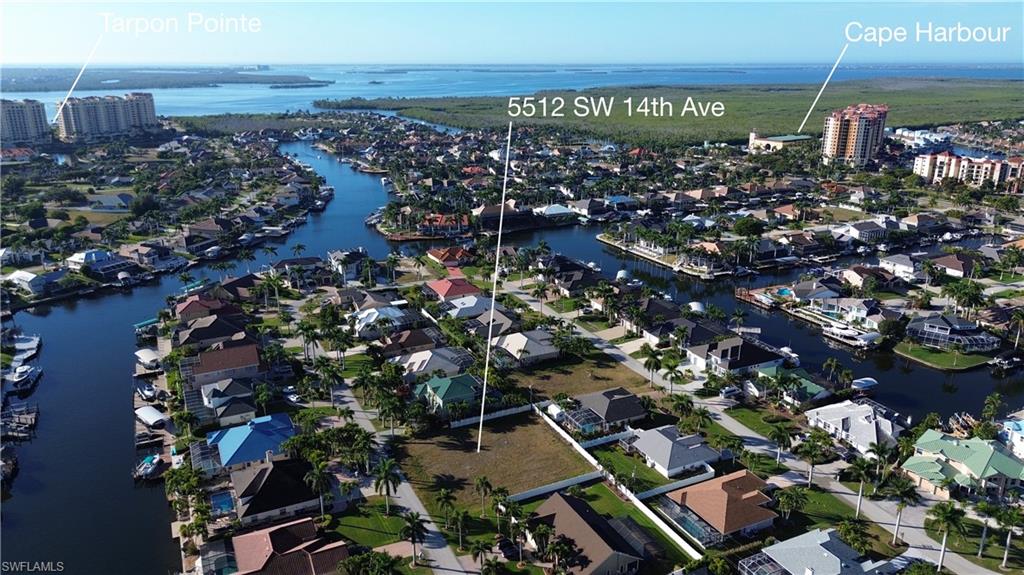 Aerial view of property and surrounding area featuring a nearby body of water
