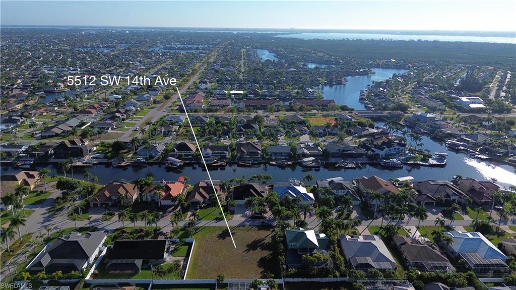 Aerial view of property's location with nearby suburban area and a nearby body of water