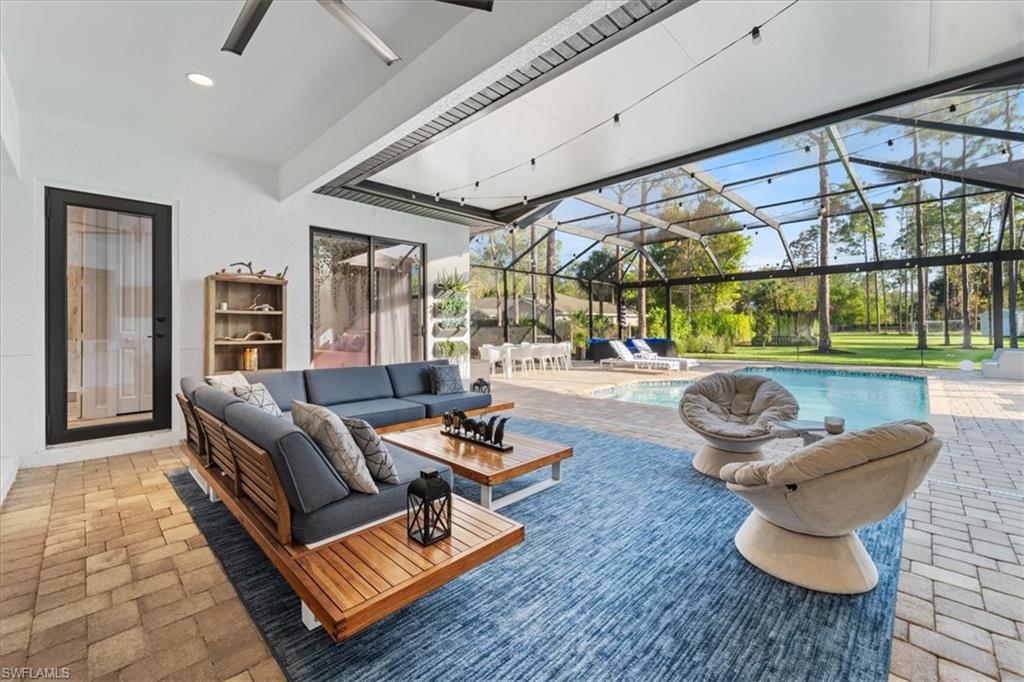 View of patio featuring a lanai, an outdoor pool, an outdoor hangout area, and a ceiling fan