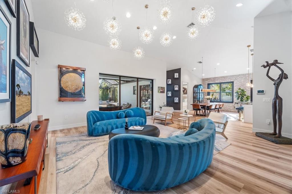 Living room featuring recessed lighting, a high ceiling, baseboards, and wood finished floors