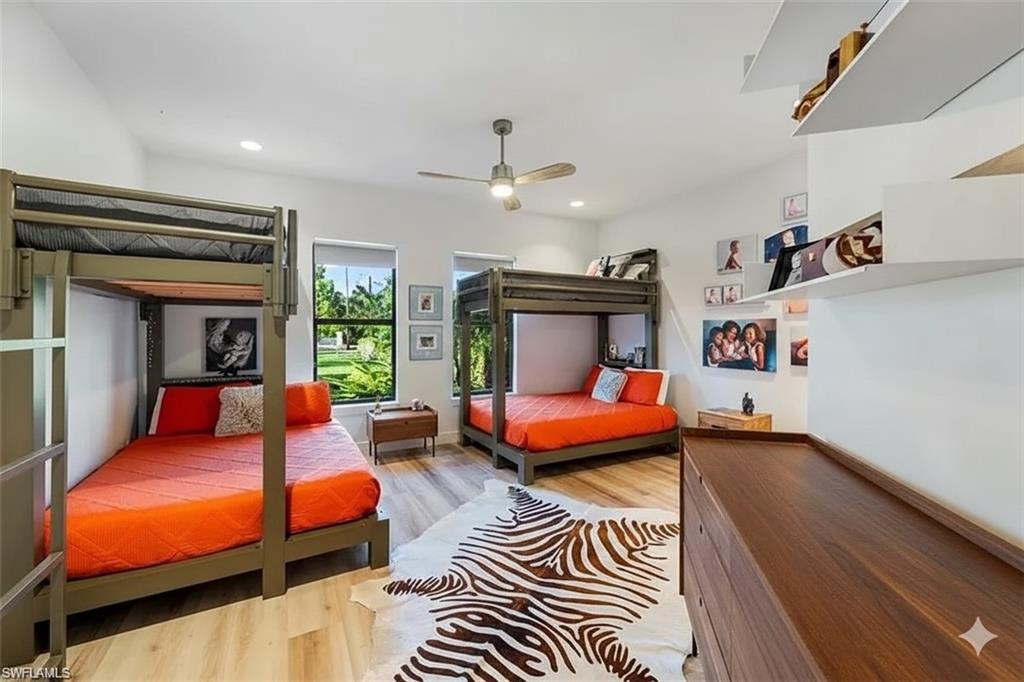 Bedroom with light wood finished floors, ceiling fan, and recessed lighting