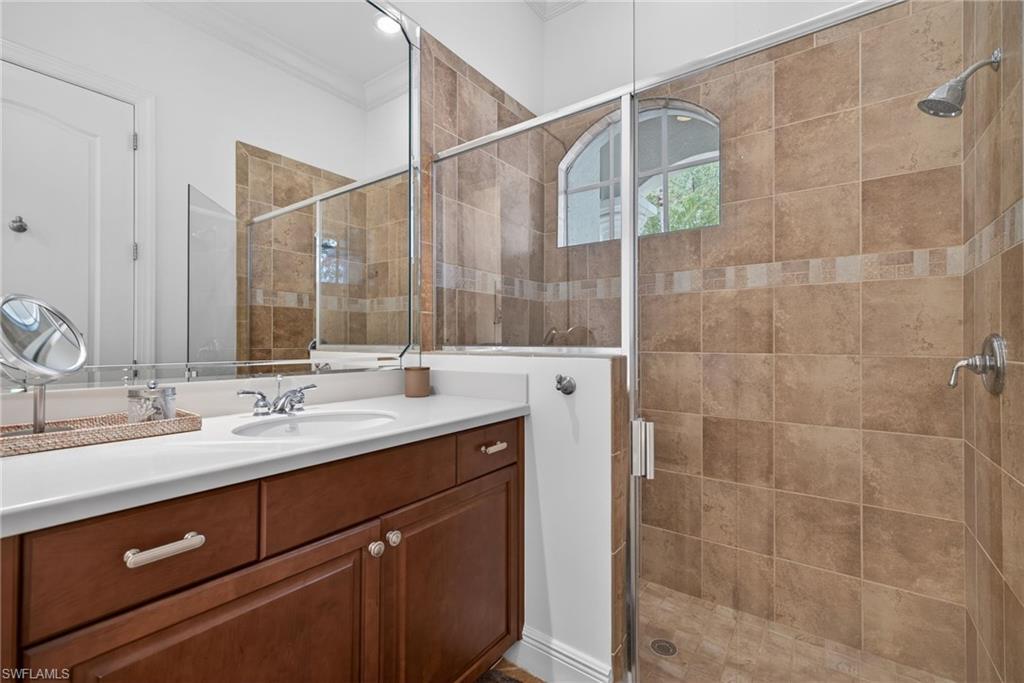 Full bath with crown molding, vanity, and a shower stall