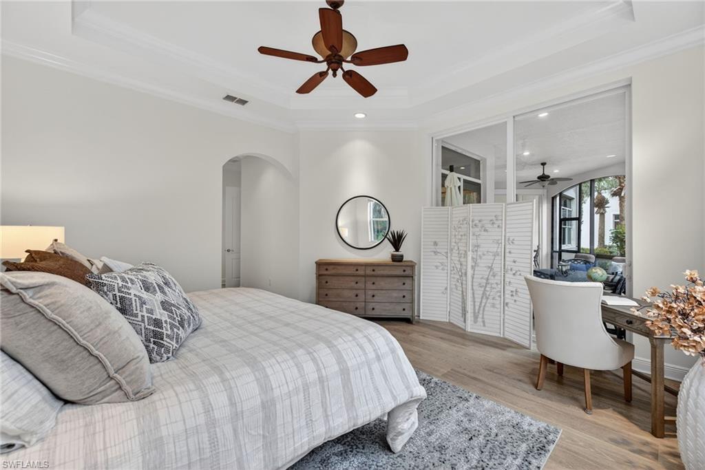 Bedroom featuring ceiling fan, light wood finished floors, arched walkways, recessed lighting, and crown molding
