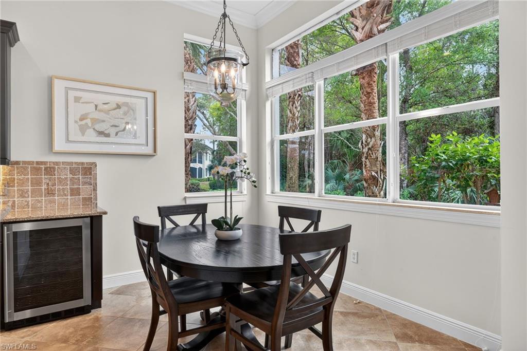 Dining room with beverage cooler, crown molding, and a chandelier