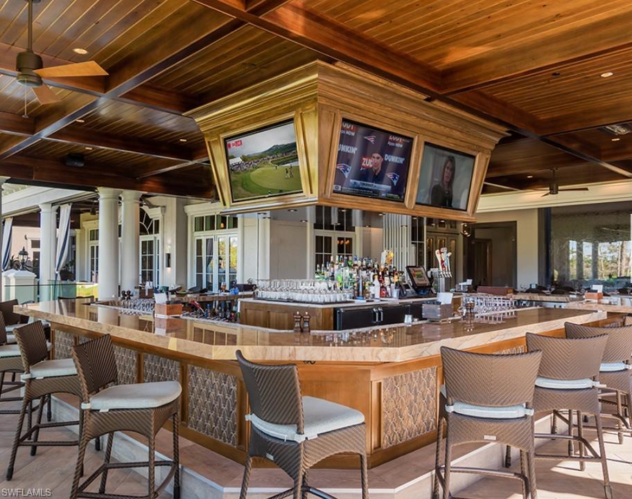 Bar area with a wooden ceiling with exposed beams, coffered ceiling, recessed lighting, and glass insert cabinets