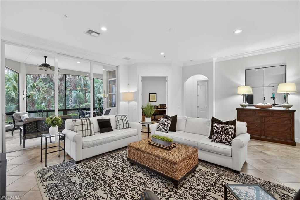 Living room with crown molding, recessed lighting, a ceiling fan, arched walkways, and light tile patterned flooring