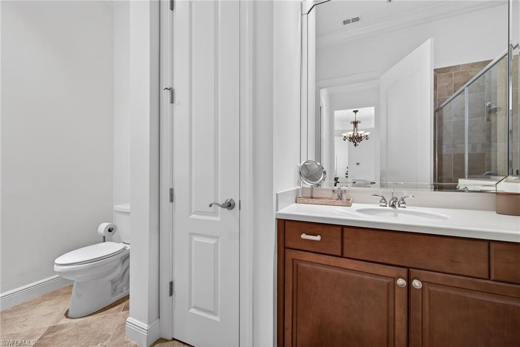 Bathroom with a stall shower, vanity, a chandelier, and ornamental molding