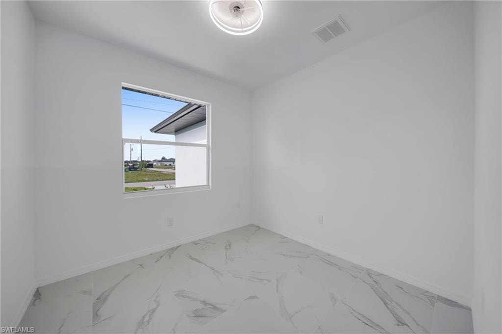 Unfurnished room with light marble finish floors