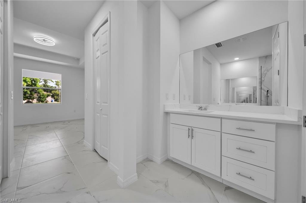 Bathroom with light marble finish flooring and vanity