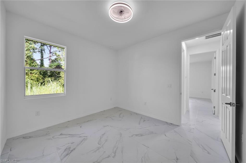 Empty room with light marble finish flooring and baseboards