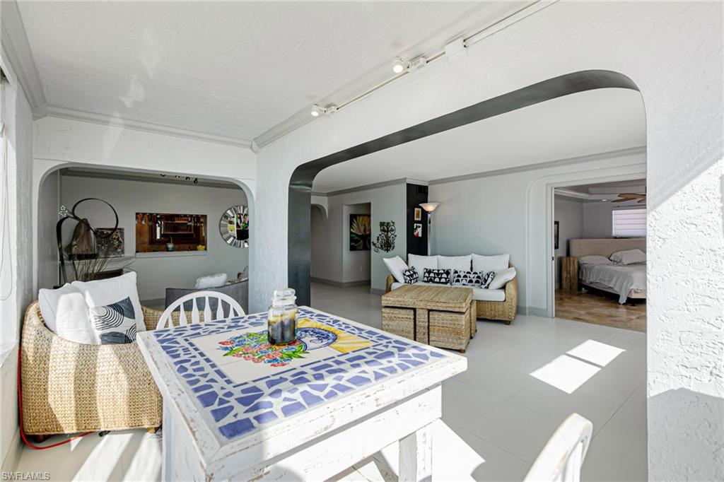 Dining room with arched walkways, crown molding, tile patterned floors, and rail lighting