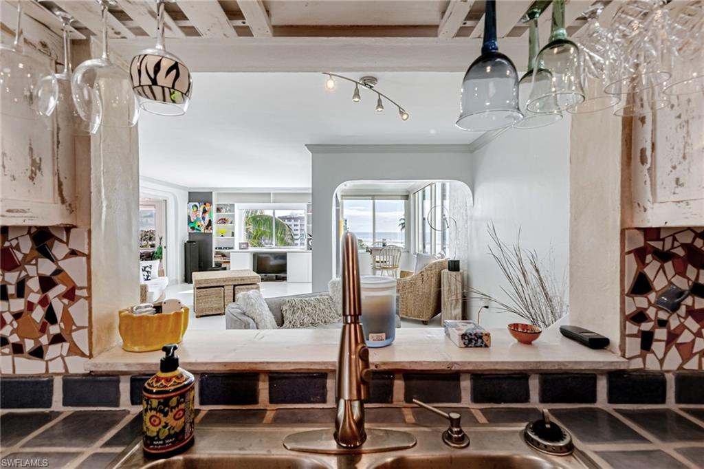 Kitchen view of backsplash, crown molding, and light countertops