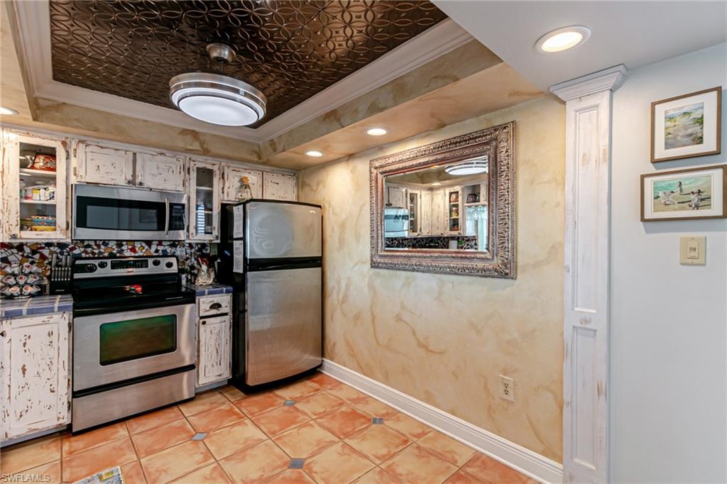 Kitchen with appliances with stainless steel finishes, crown molding, an ornate ceiling, recessed lighting, and white cabinets