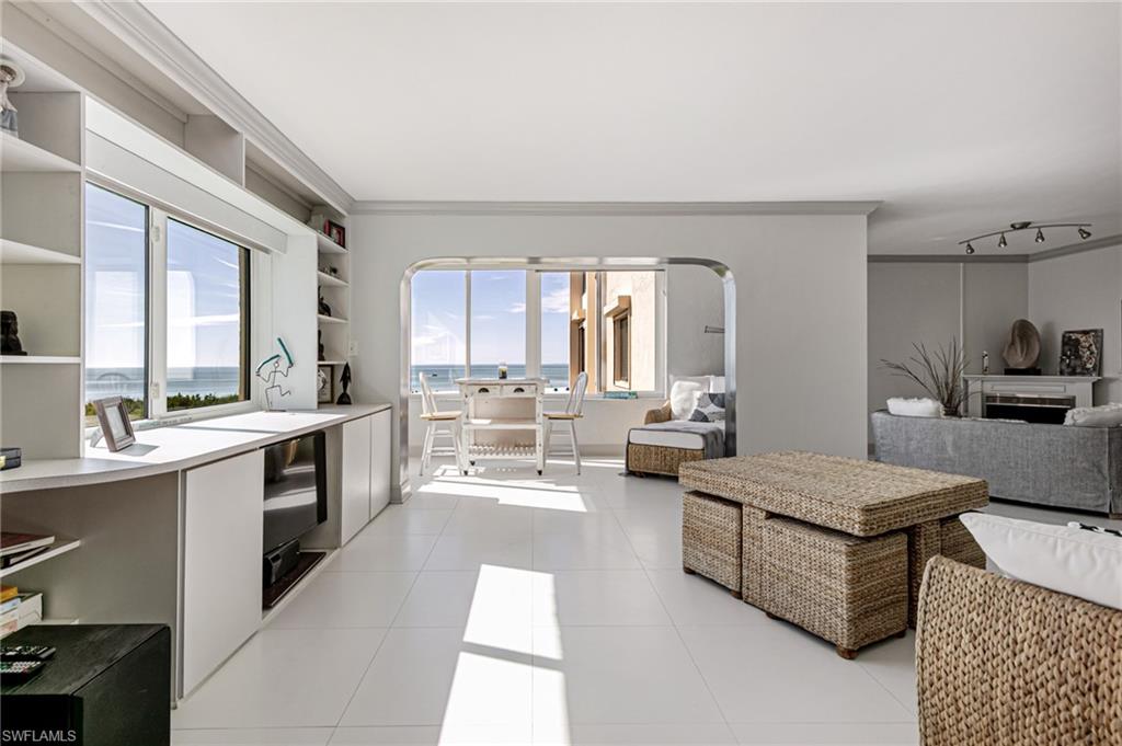 Kitchen featuring light countertops, crown molding, light tile patterned flooring, open floor plan, and open shelves