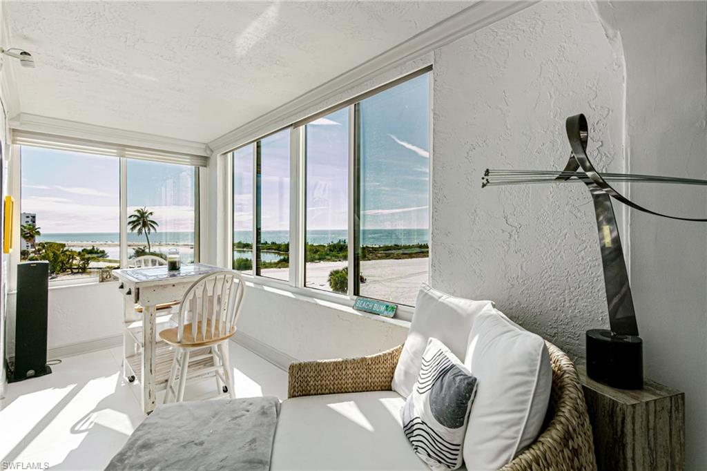 Sunroom with a textured wall and a water view