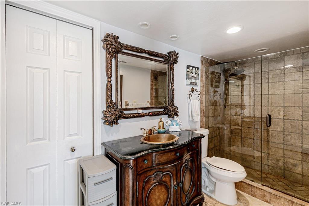 Full bathroom with vanity, a stall shower, and a closet