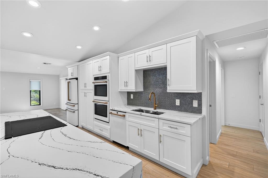 New GE Cafe appliances, light stone countertops, custom cabinets, vaulted ceilings, luxury lighting