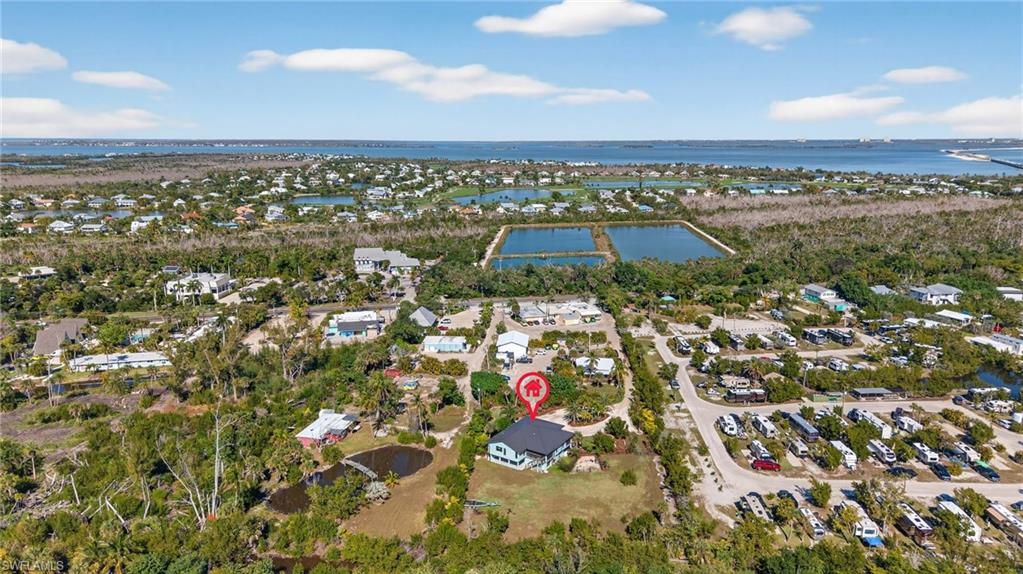 Aerial view of property and surrounding area featuring nearby suburban area and a nearby body of water