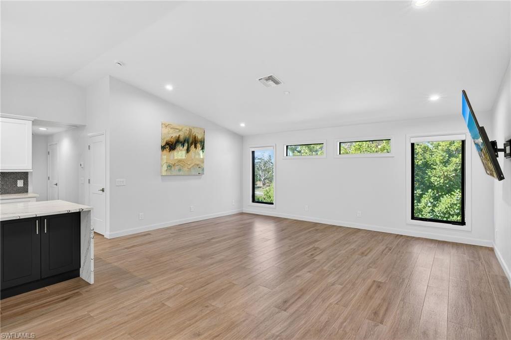 Living room with recessed lighting and vaulted ceilings.
