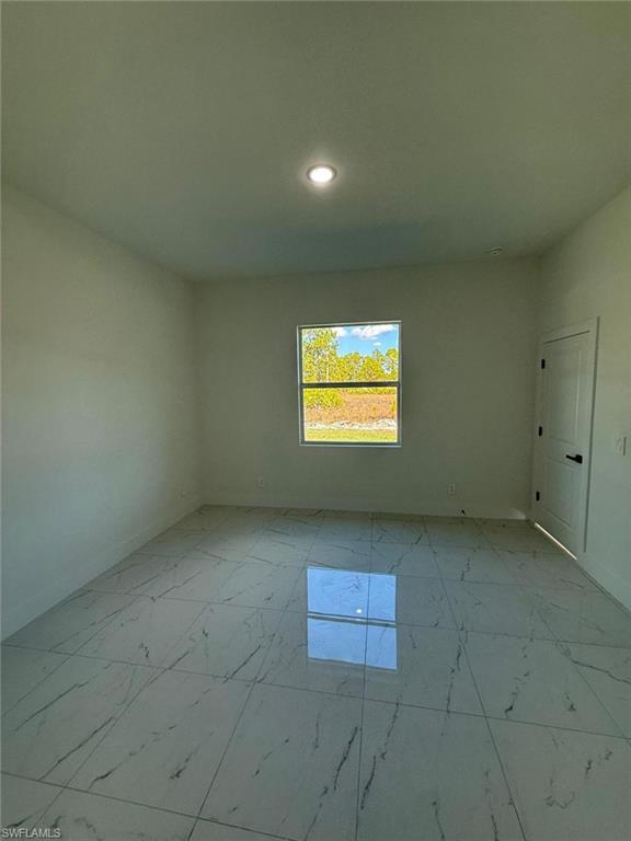 Spare room featuring light marble finish floors and recessed lighting