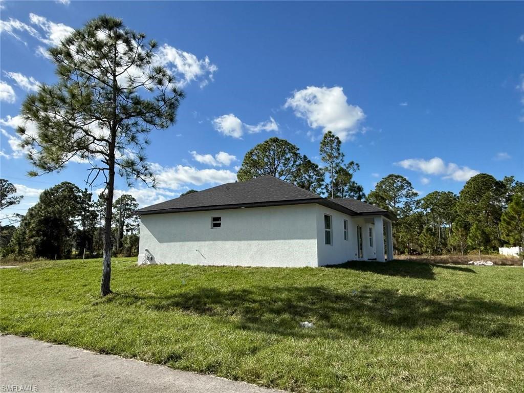 View of property exterior featuring a yard and stucco siding