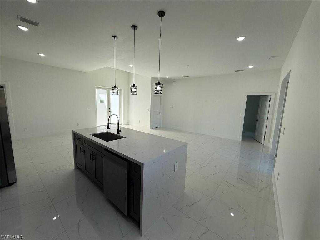 Kitchen with light marble finish floors, open floor plan, light stone countertops, and recessed lighting