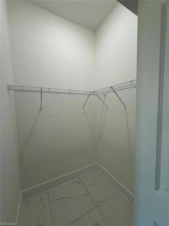 Spacious closet with light marble finish floors
