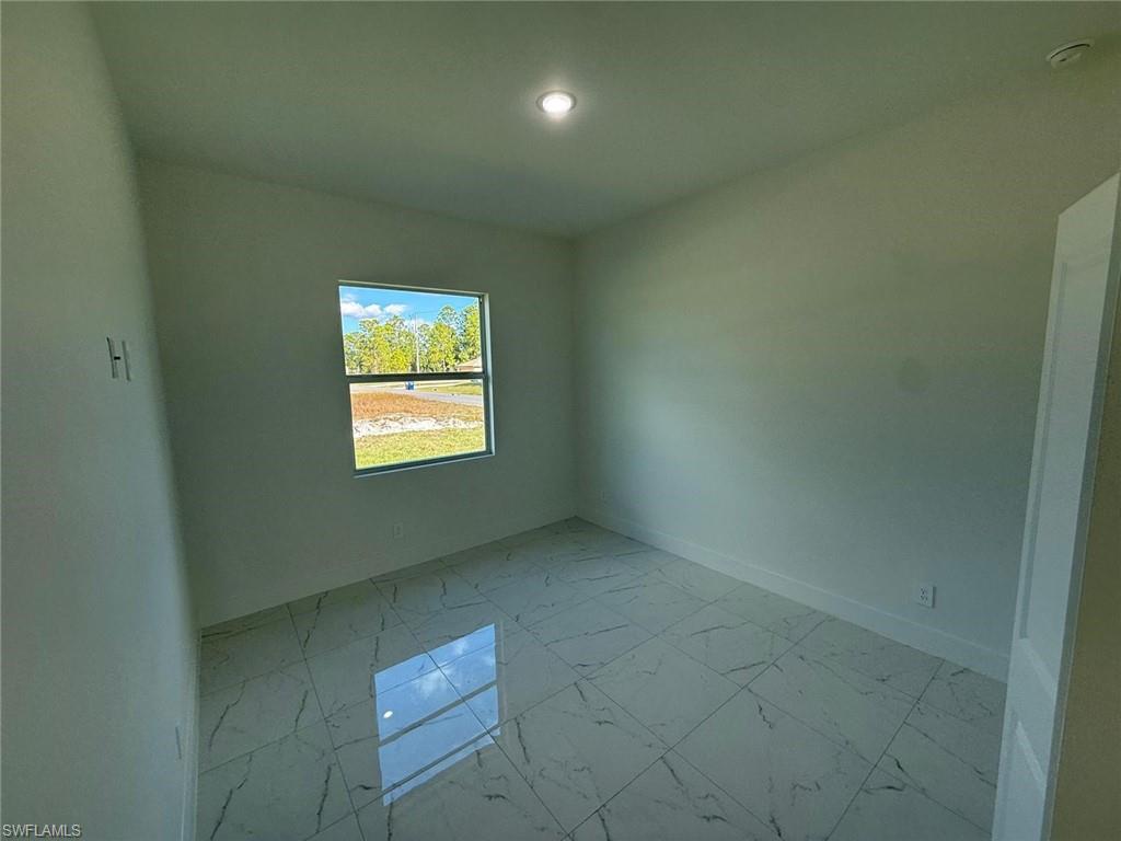 Unfurnished room with light marble finish flooring and baseboards