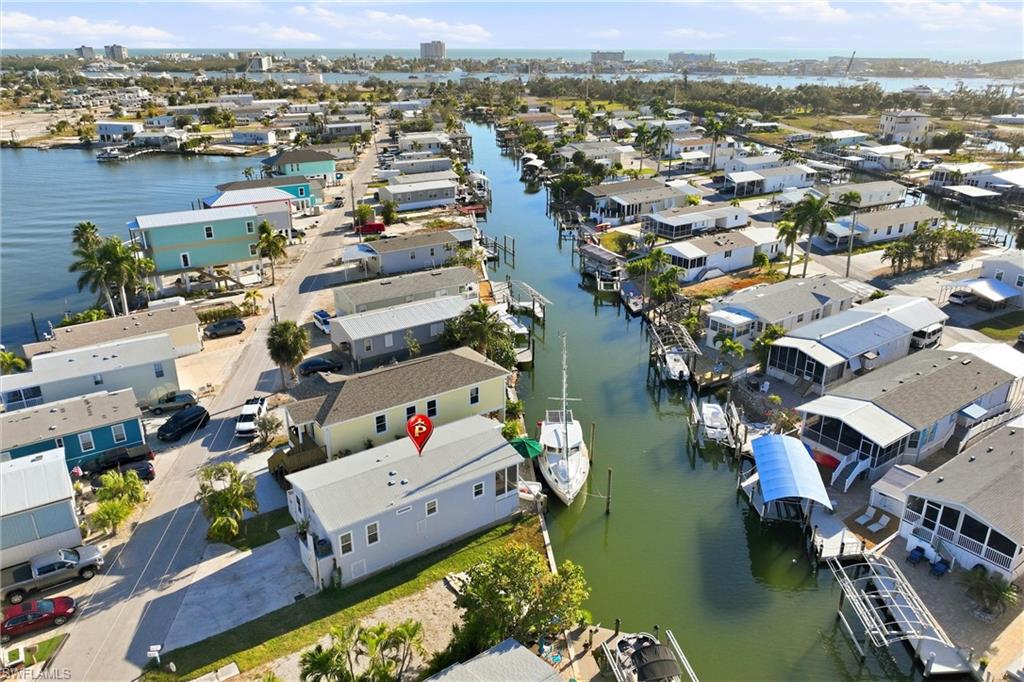 Aerial view of property and surrounding area featuring a large body of water and nearby suburban area